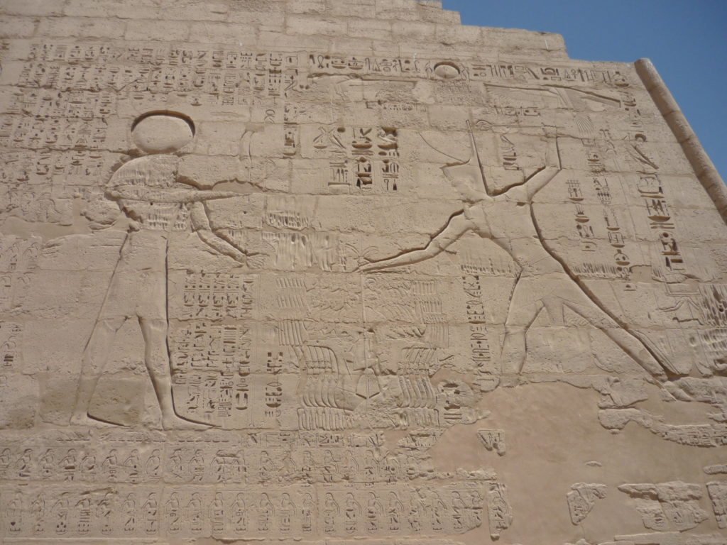 Il rilievo su una parete del tempio di Medinet habu in cui Ramses III, di fronte ad Ammon Ra, soggioga un gruppo di prigionieri